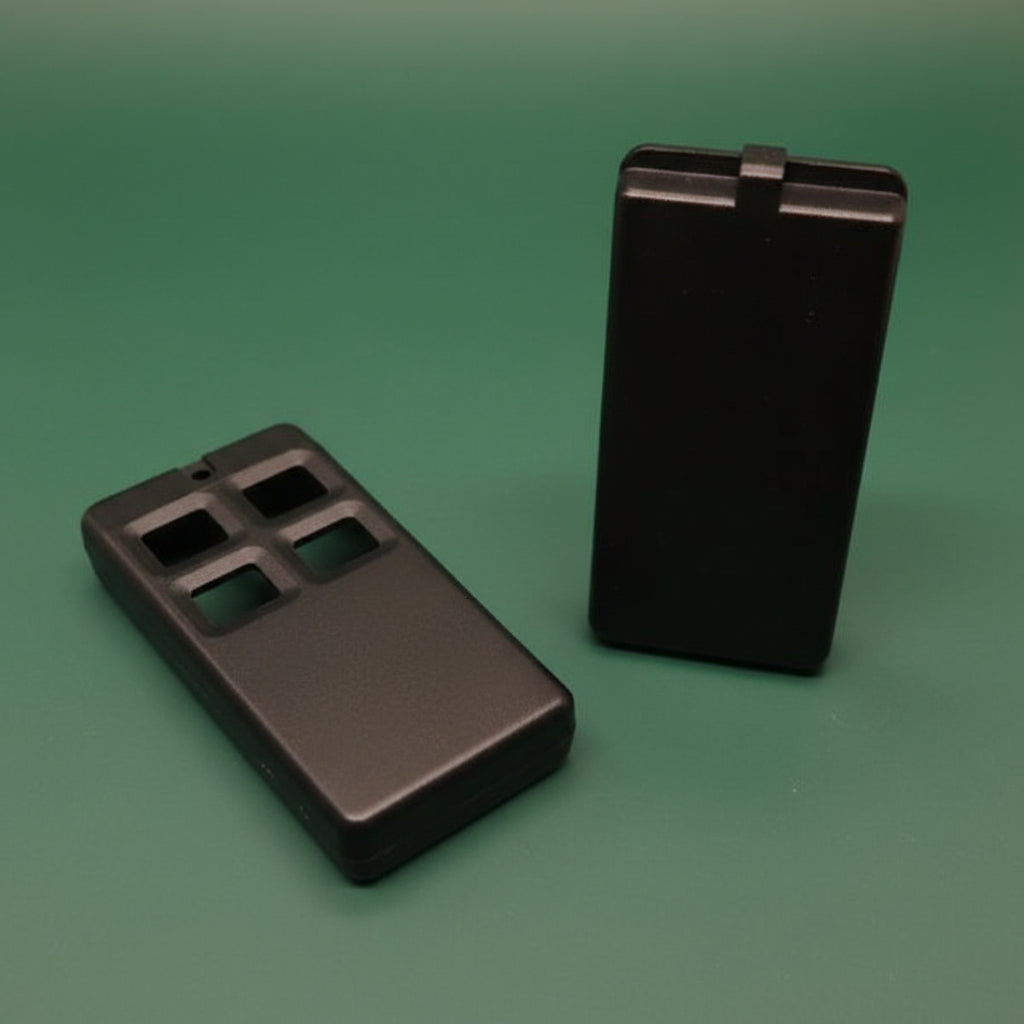 Two black plastic components on a green background
