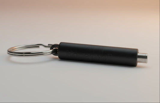 Black cylindrical keychain with a metal ring on a white background
