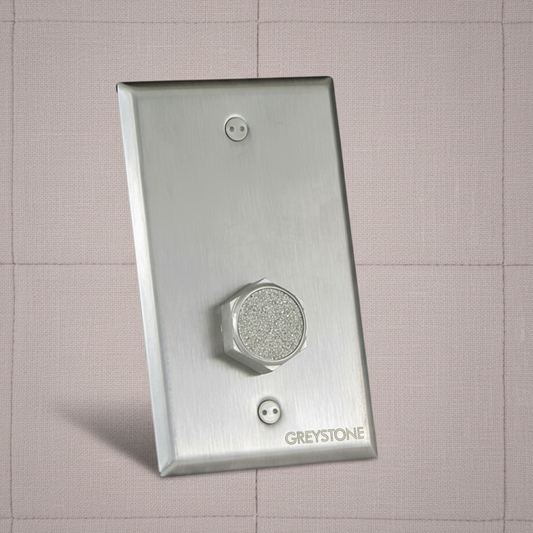 Metallic wall sensor plate with 'Greystone' branding on a tiled wall background
